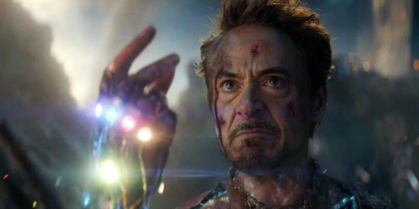 《复仇者联盟4：终局之战》剧照：Tony Stark 举起嵌着六颗无限宝石的手，打响指的瞬间。