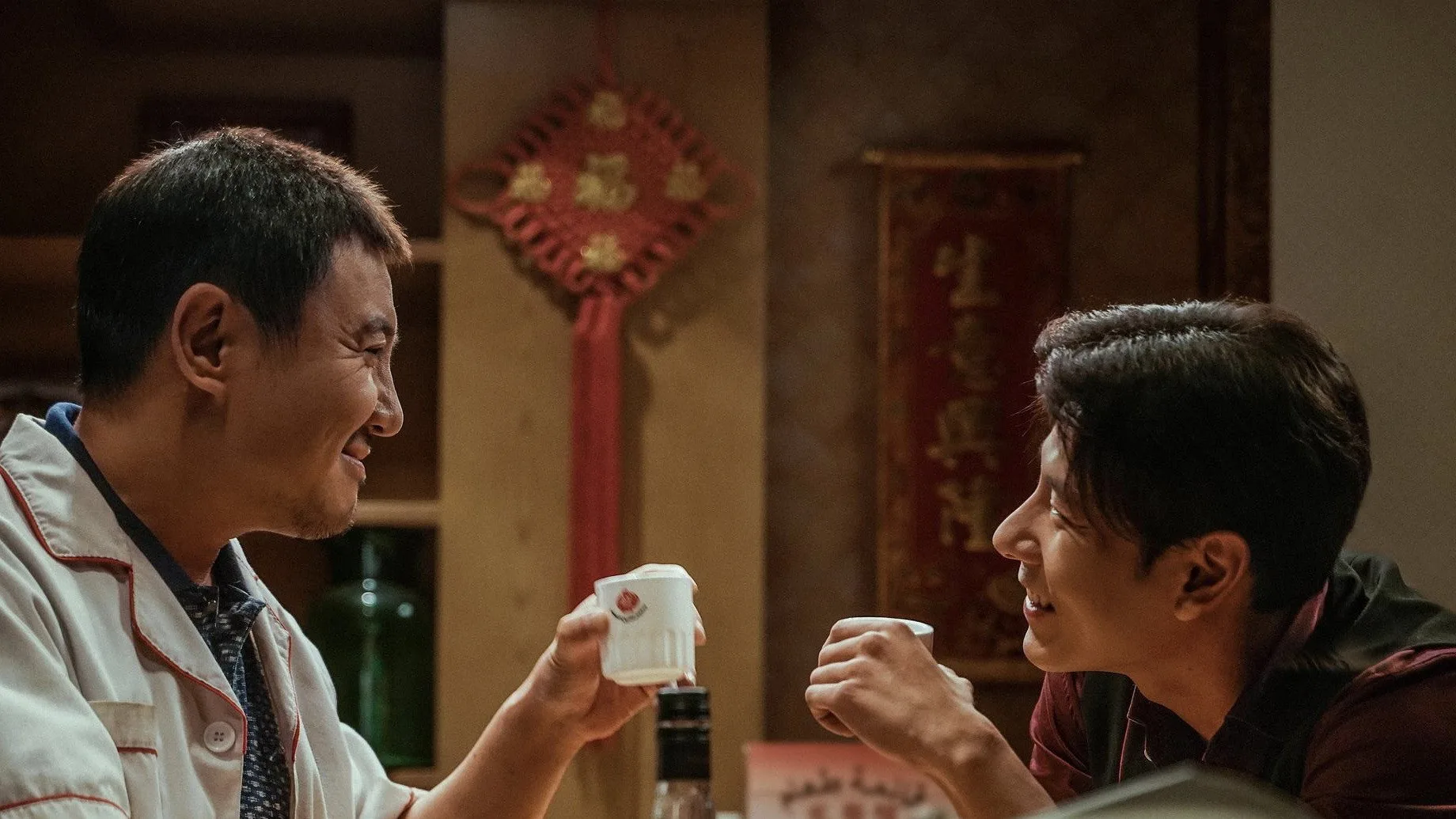徐福和马俊生在餐馆内举着茶杯相视而笑。