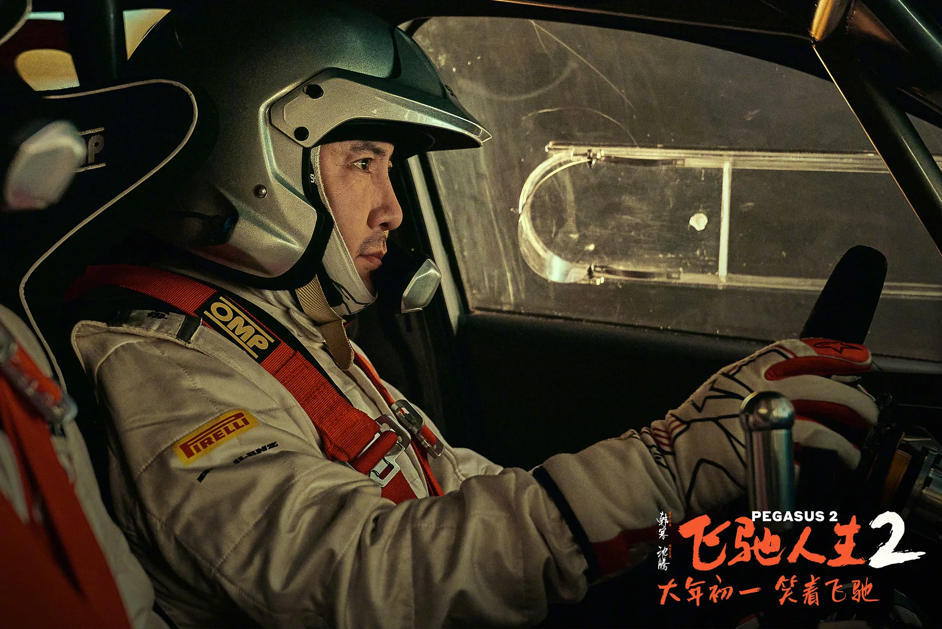 《飞驰人生2》剧照：张驰戴着头盔坐在赛车驾驶舱内，专注地望向前方。